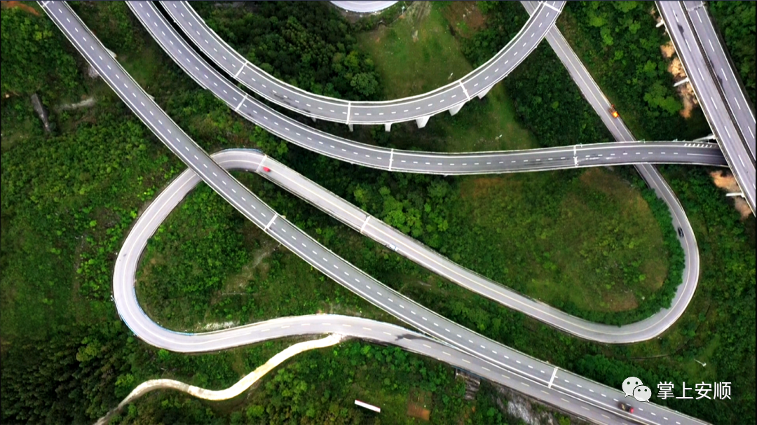 站在山巅远眺,g354国道在山峦叠嶂间蜿蜒向前,公路旁的河流中鱼翔浅底