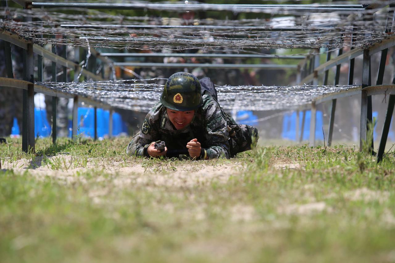 单兵战术比武场上,参赛民兵铆足劲儿往上冲,一个连贯动作下来,不少